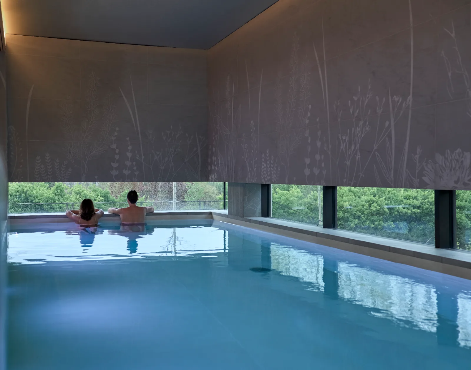 Pareja en la piscina interior de un spa